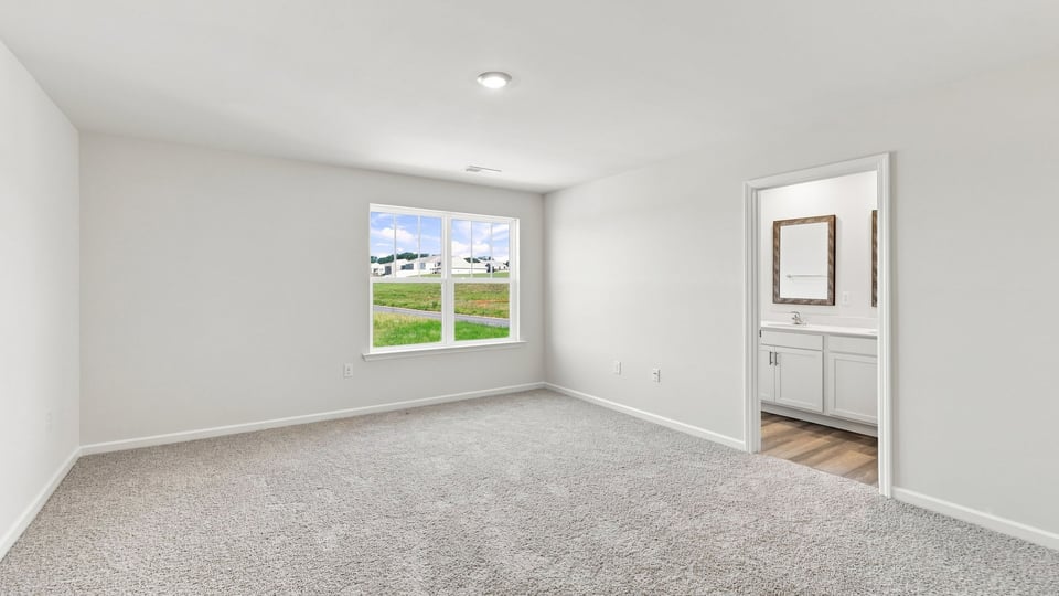 Primary bedroom with window and carpet.