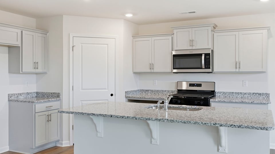Kitchen and island with granite counter tops.