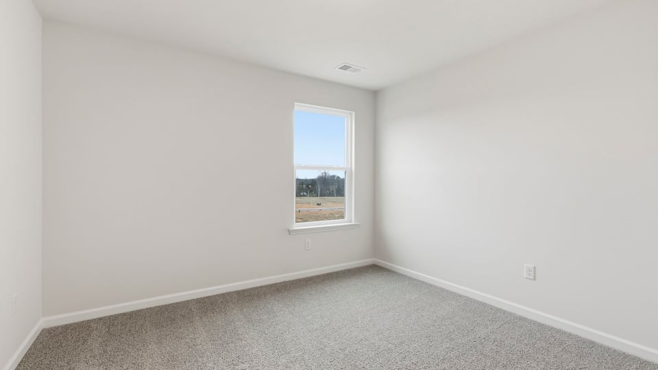 Bedroom with carpet and window.