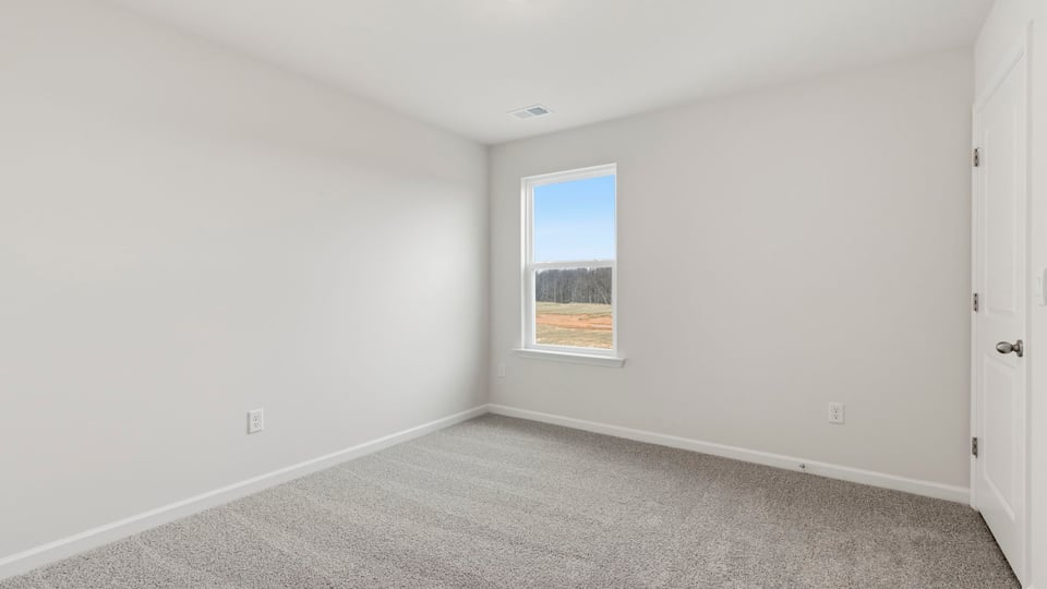 Bedroom with carpet and window.