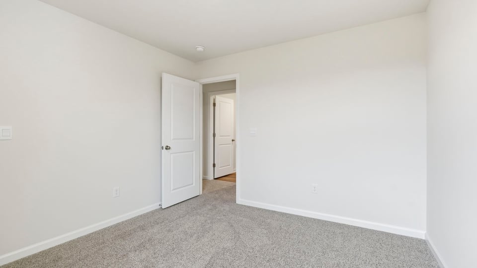 Bedroom with carpet and window.