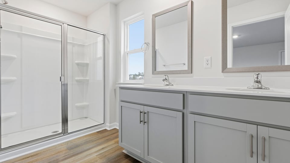 Bathroom with double sink and walk in shower.