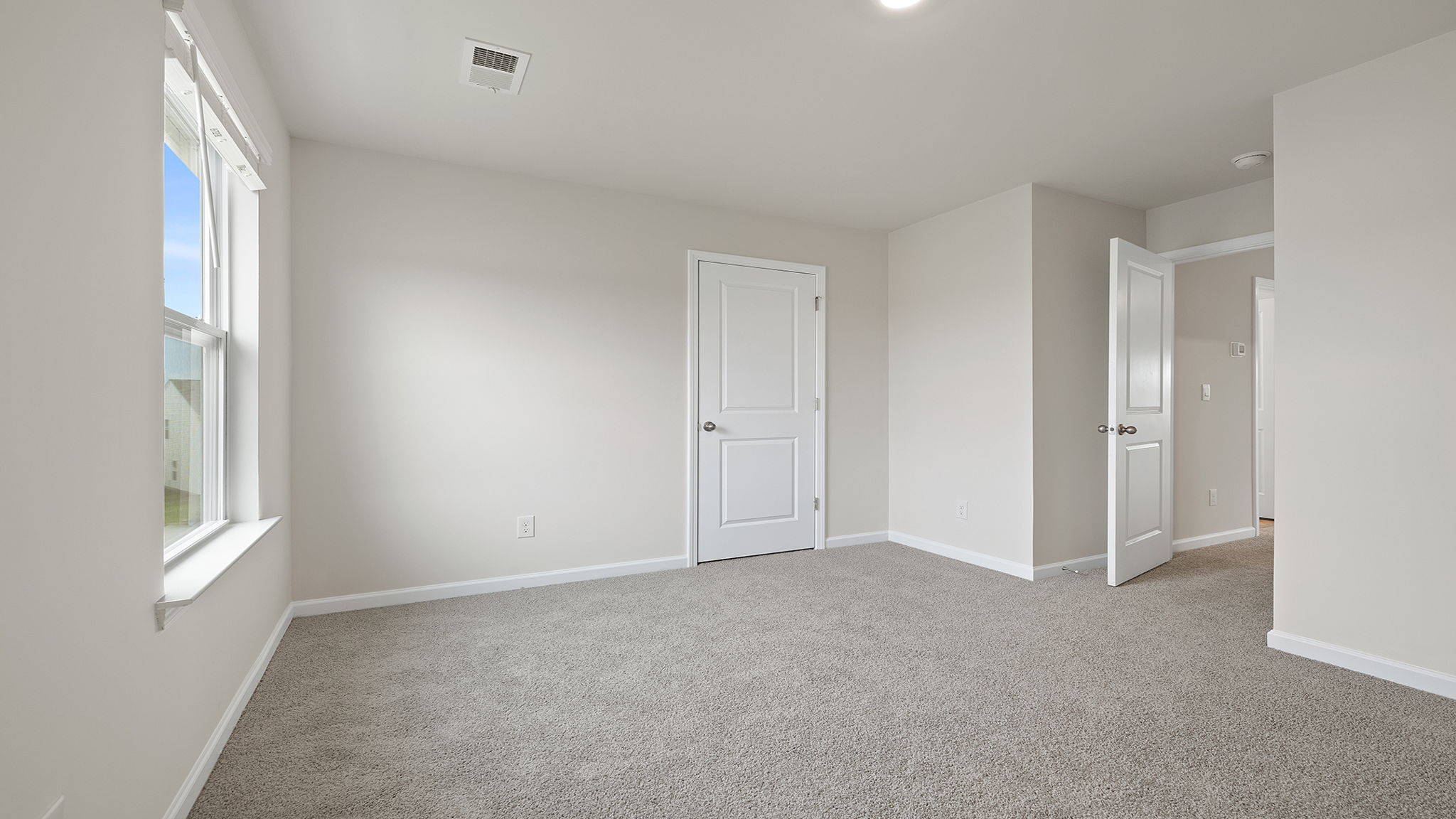 Bedroom with carpet and window.