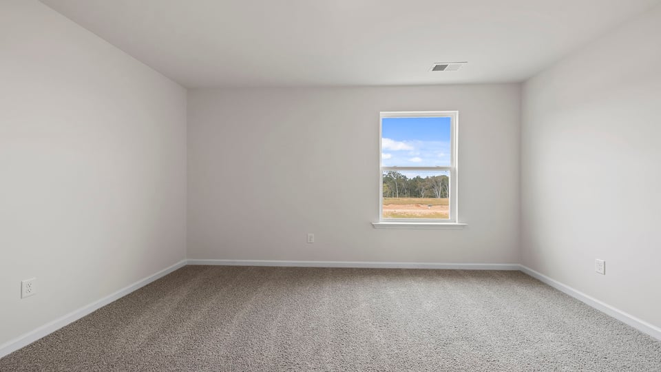 Bedroom with carpet and windows.