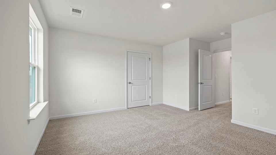 Bedroom with carpet and windows.
