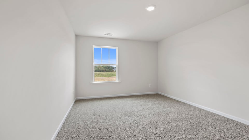 Bedroom with carpet and windows.