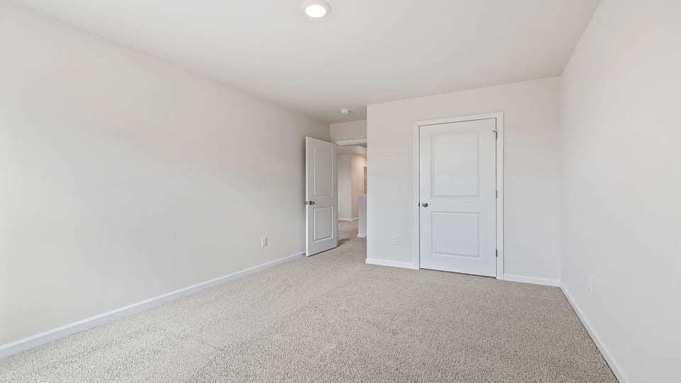 Bedroom with carpet and windows.