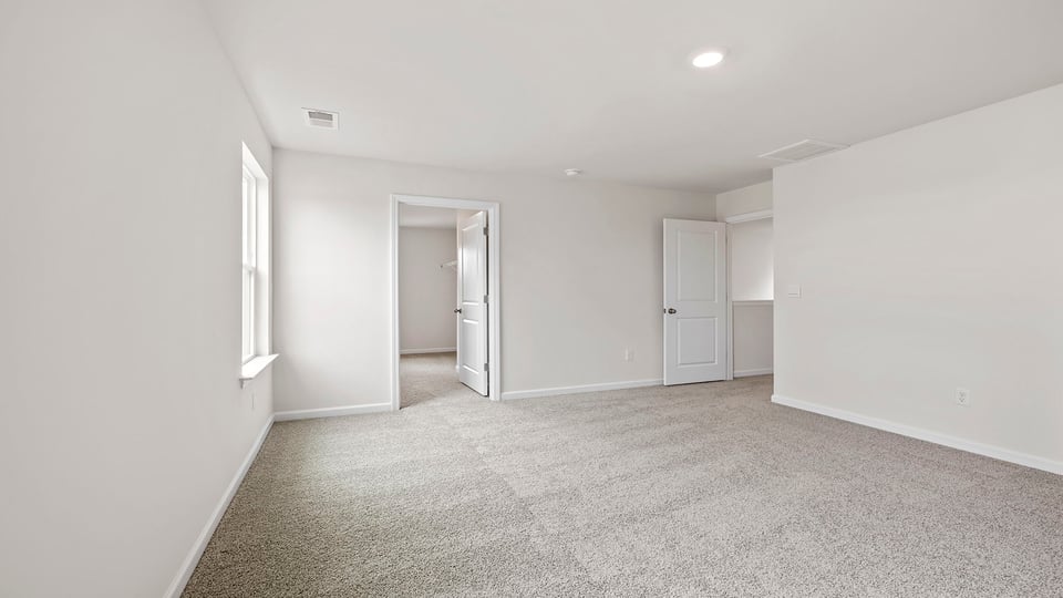 Bedroom with carpet and windows.