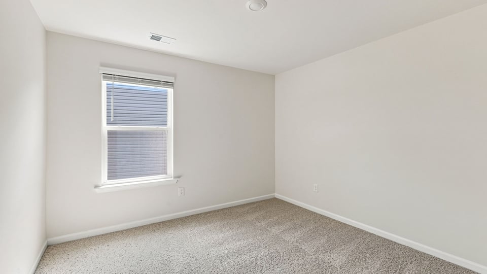 Bedroom with carpet and windows.