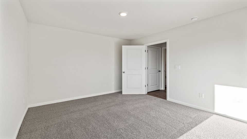Bedroom with carpet and windows.