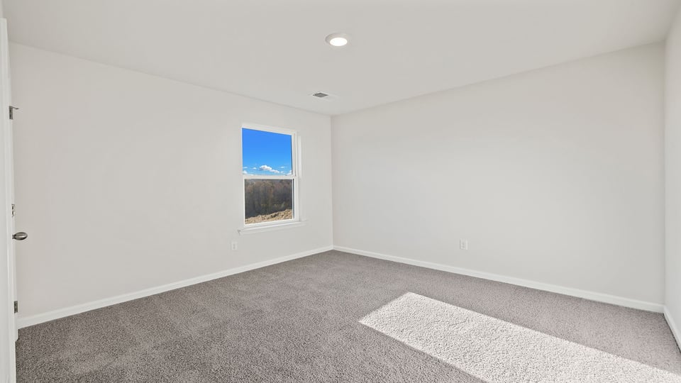 Bedroom with carpet and windows.