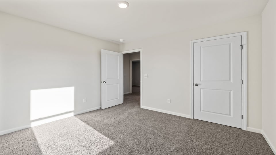 Bedroom with carpet and windows.