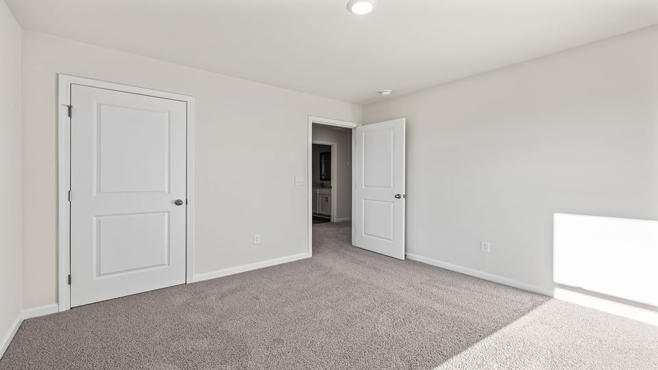 Bedroom with carpet and windows.