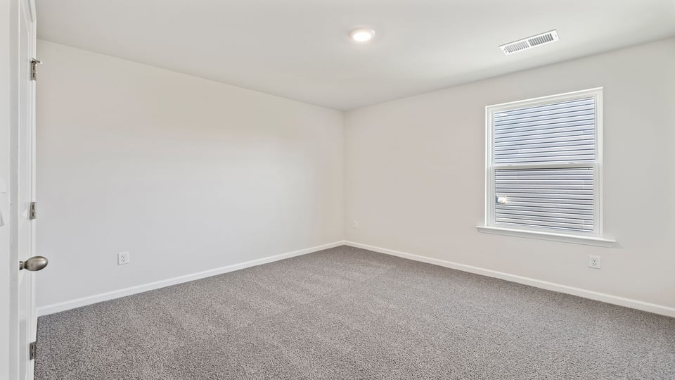 Bedroom with carpet and windows.