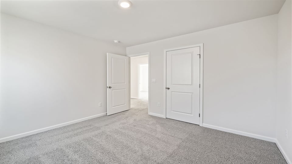 Bedroom with carpet and windows.