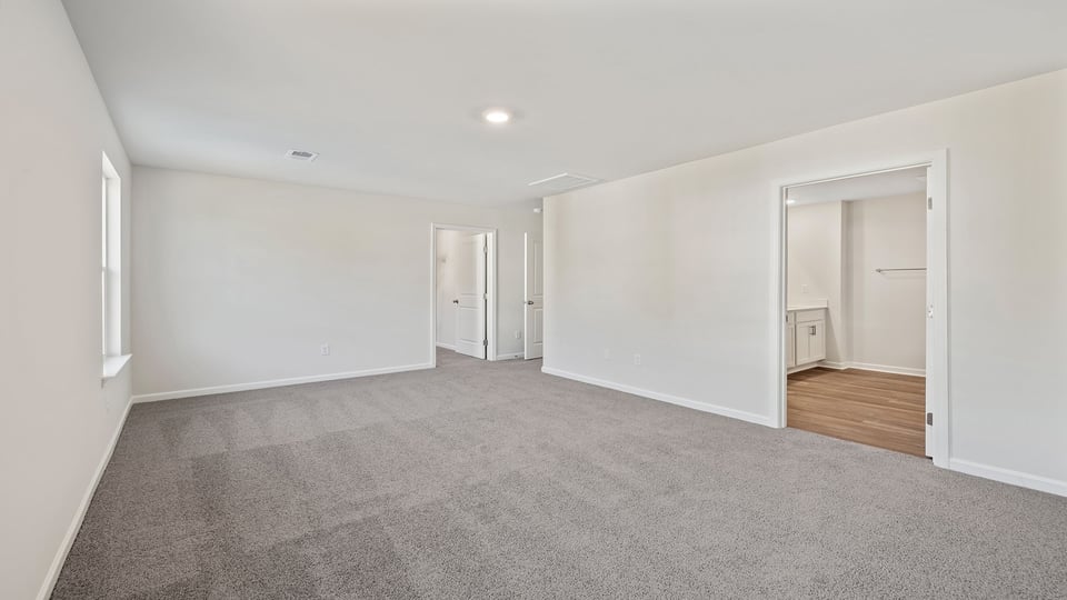 Bedroom with carpet and windows.