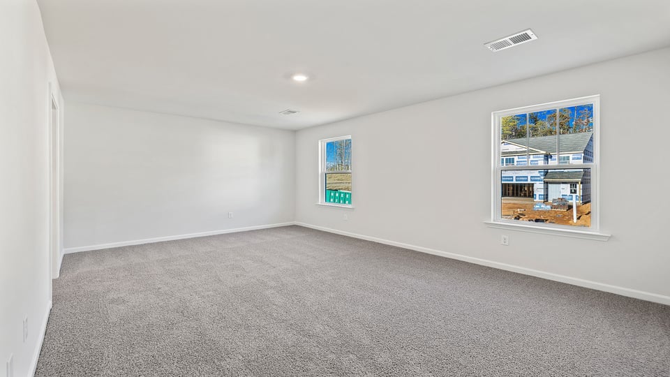 Bedroom with carpet and windows.