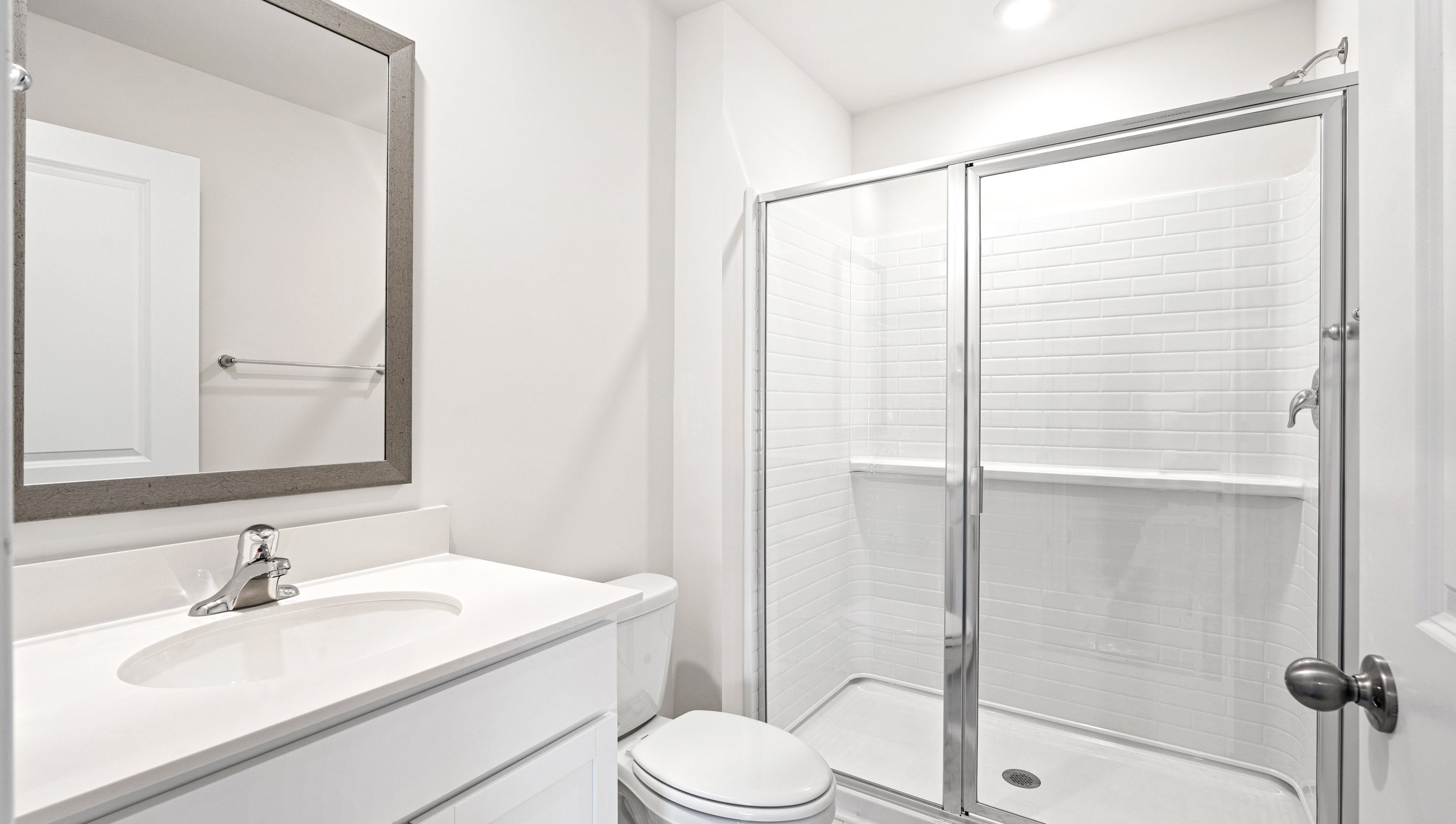 Bathroom with vanity and walk in shower.