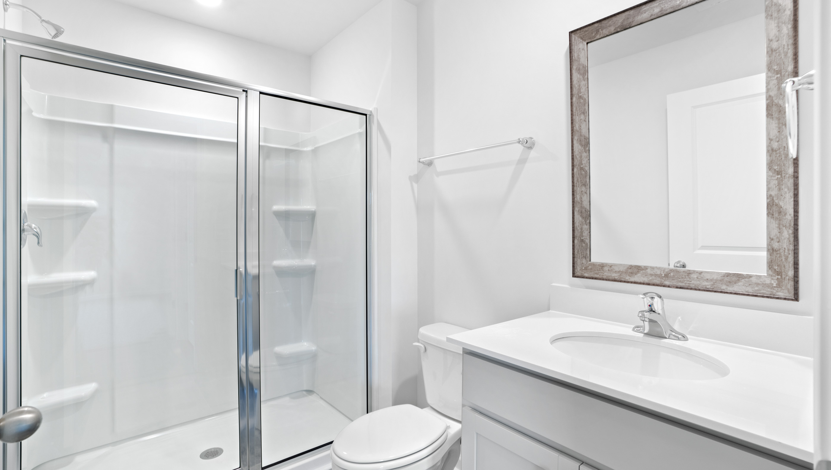 Bathroom with vanity and walk in shower.