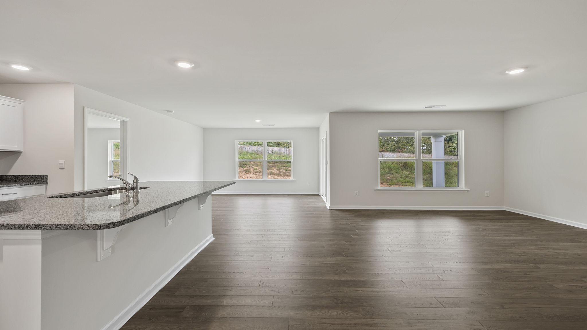 Living room and kitchen with windows.