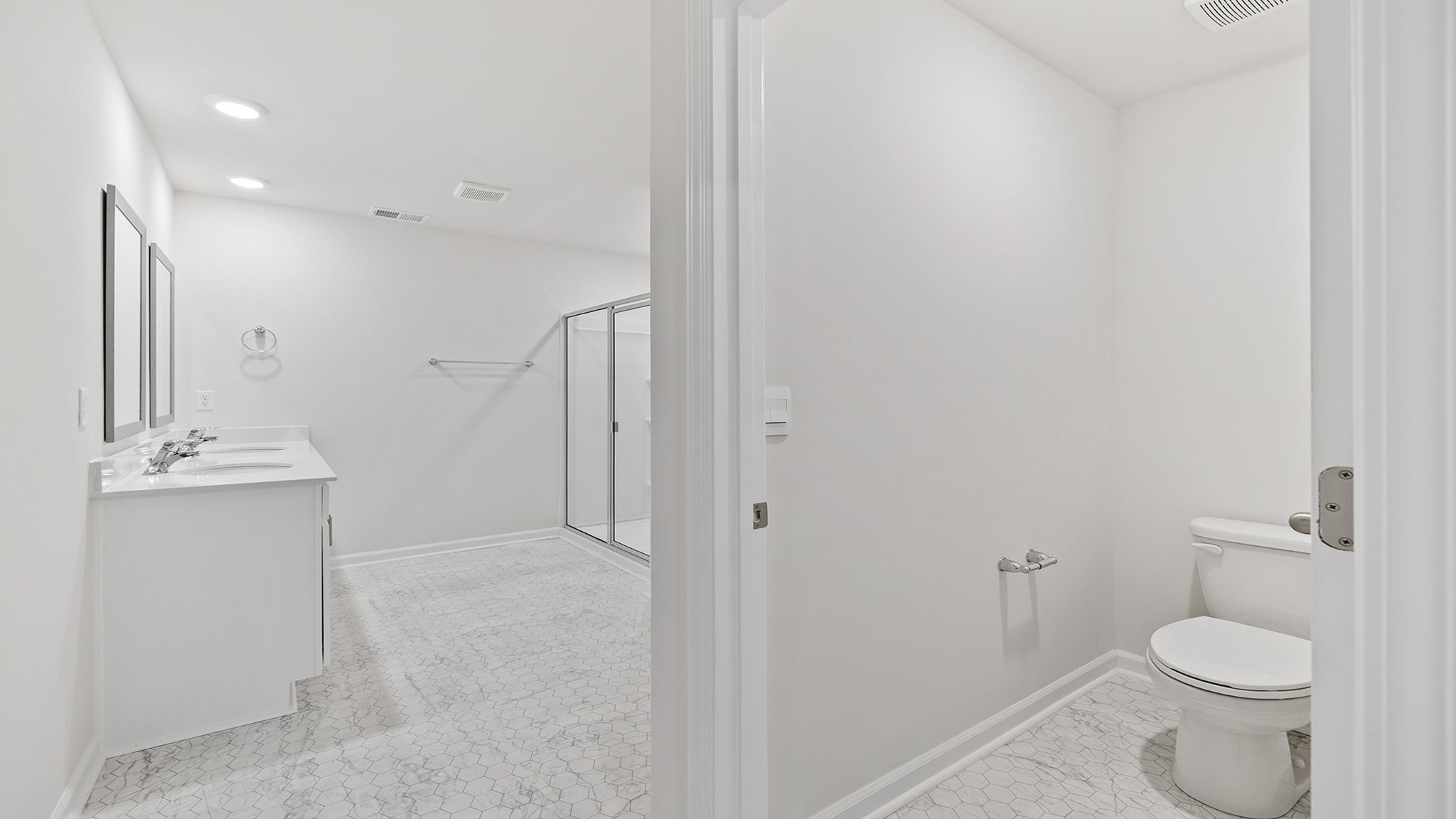 Bathroom with dual vanity and walk in shower.