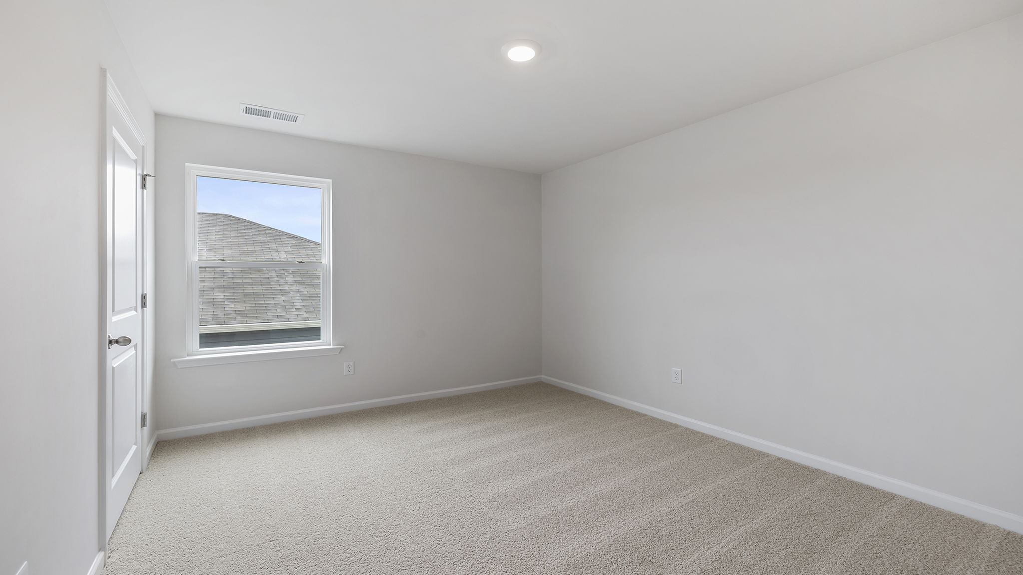 Bedroom with carpet and window.