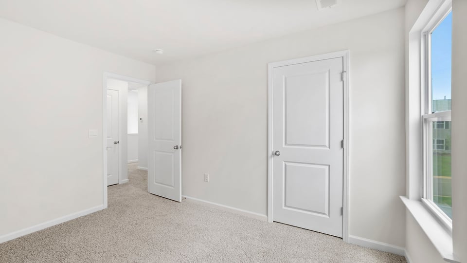 Bedroom with carpet and window.