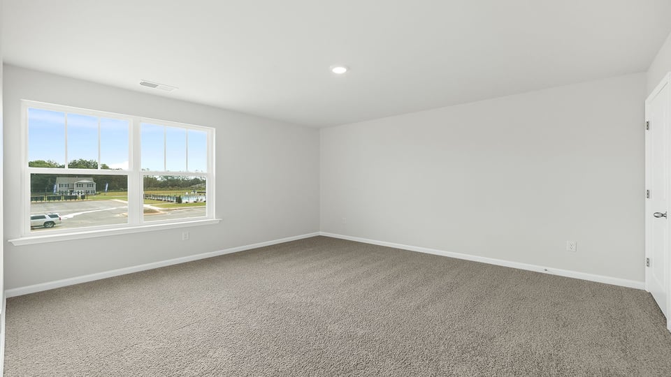 Bedroom with carpet and window.