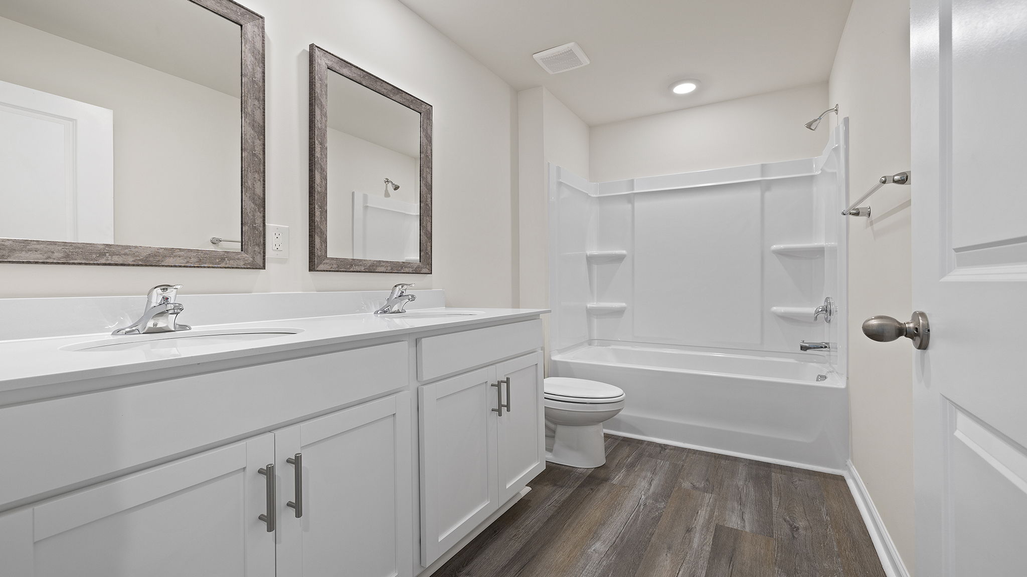 Bathroom with double sink closet and tub.