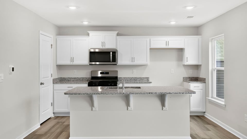 Kitchen and island with quartz countertops.