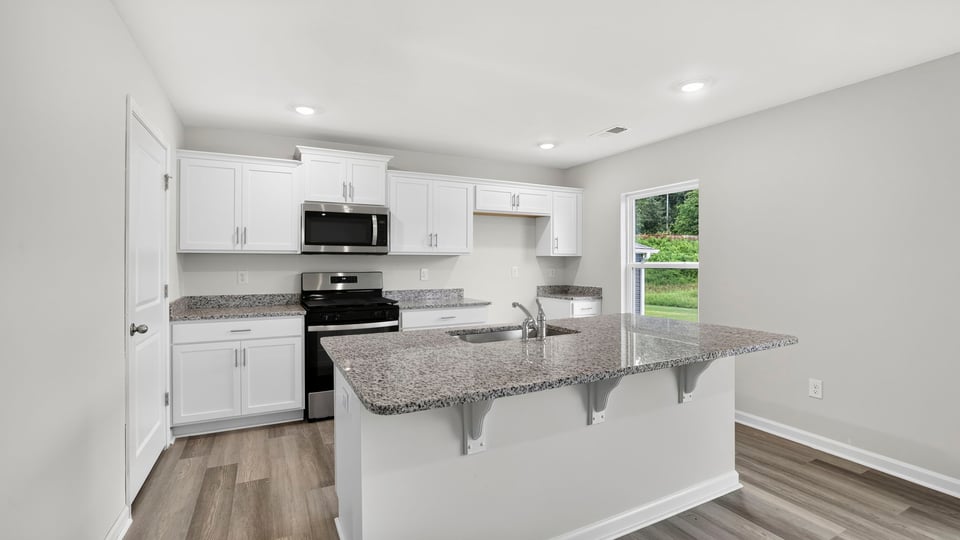 Kitchen and island with quartz countertops.