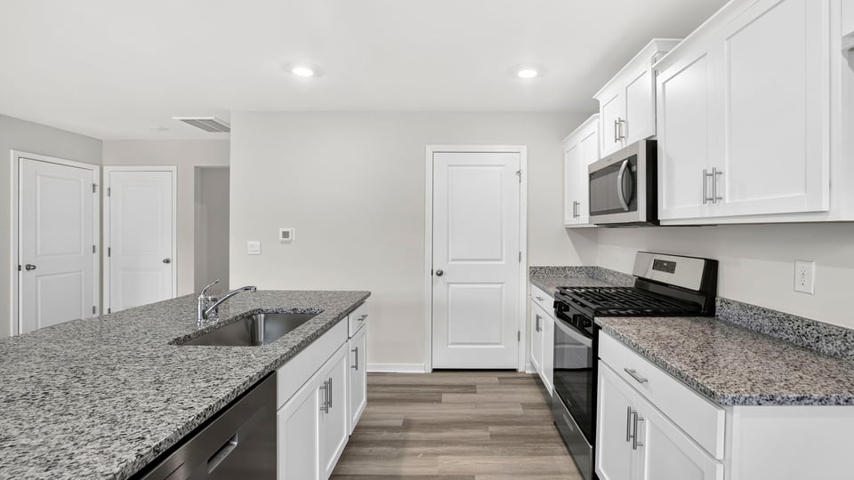 Kitchen and island with quartz countertops.