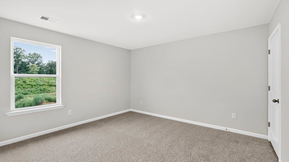 Bedroom with carpet and window.