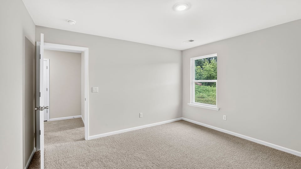 Bedroom with carpet and window.
