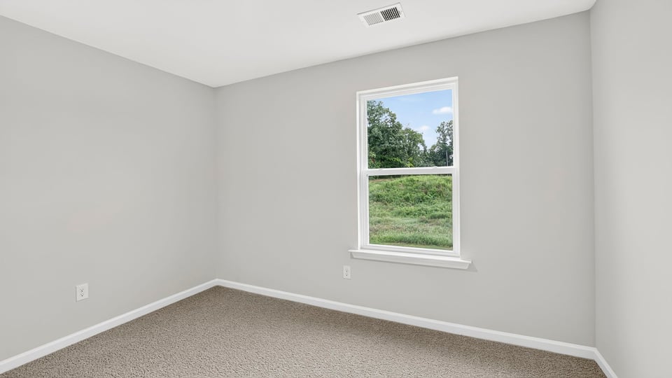 Bedroom with carpet and window.