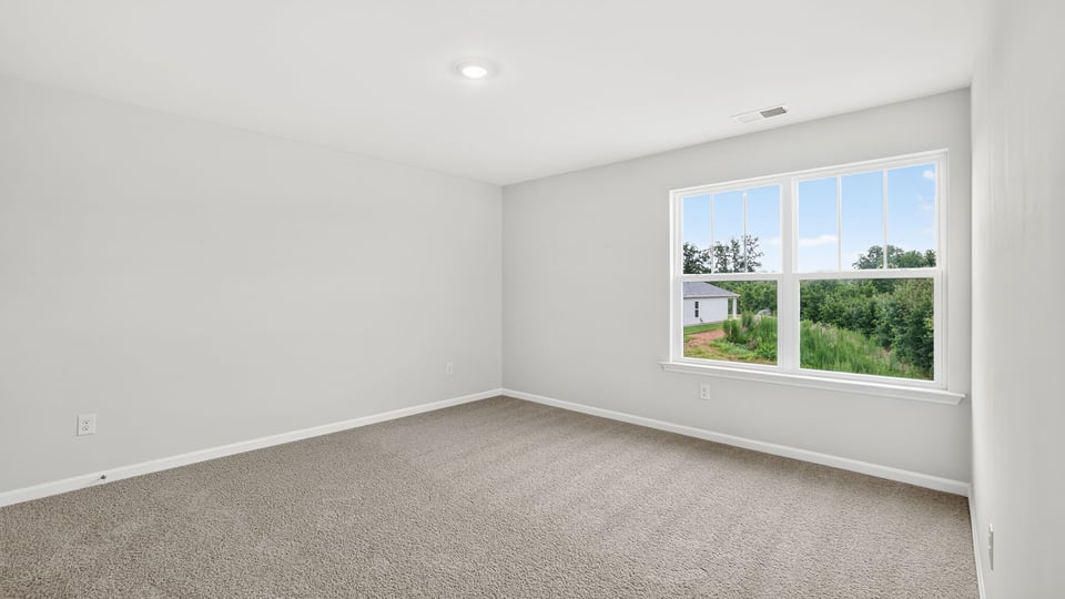 Bedroom with carpet and window.