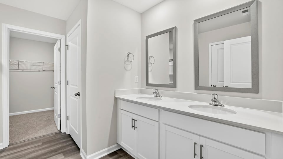 Bathroom with double vanity sink and walk in closet.