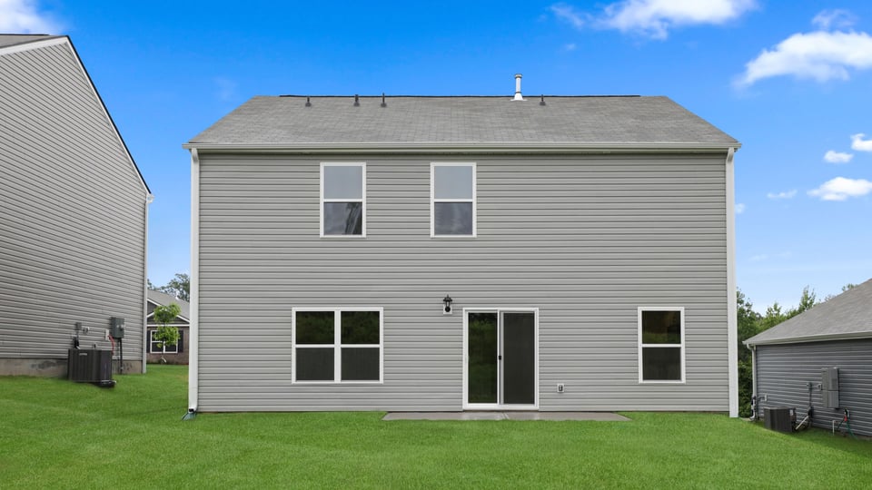 Back exterior of home with large backyard.