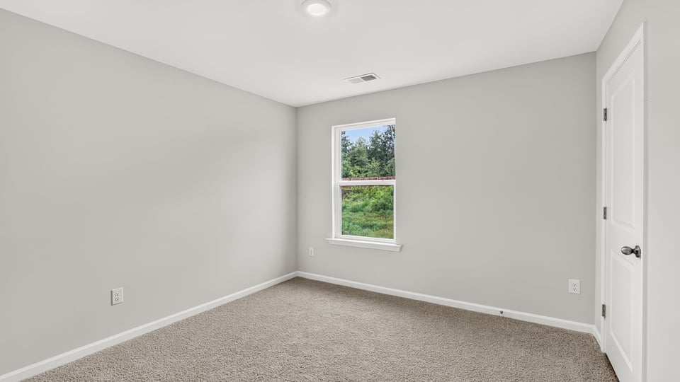 Bedroom with carpet and window.