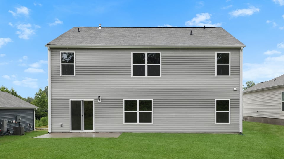 back exterior of home with large backyard.