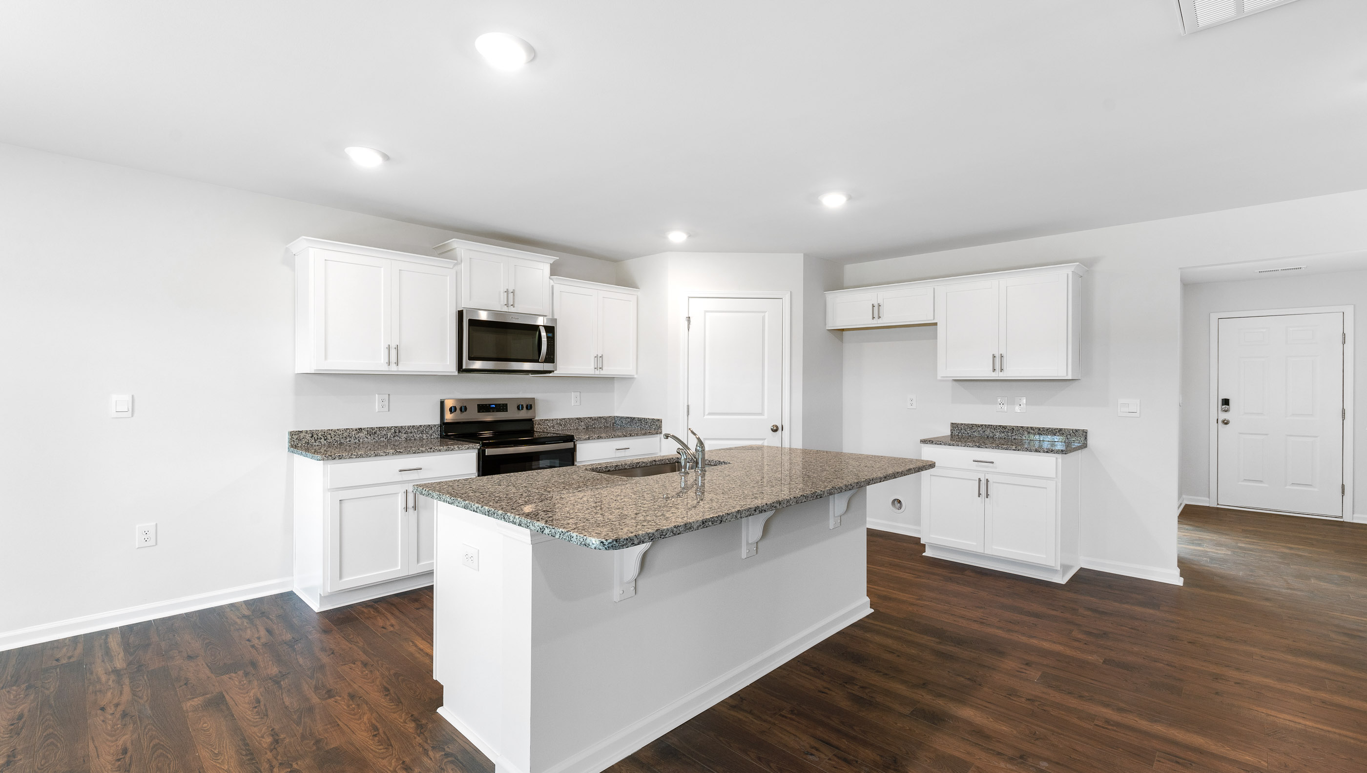 Kitchen with island with stainless steel appliances.