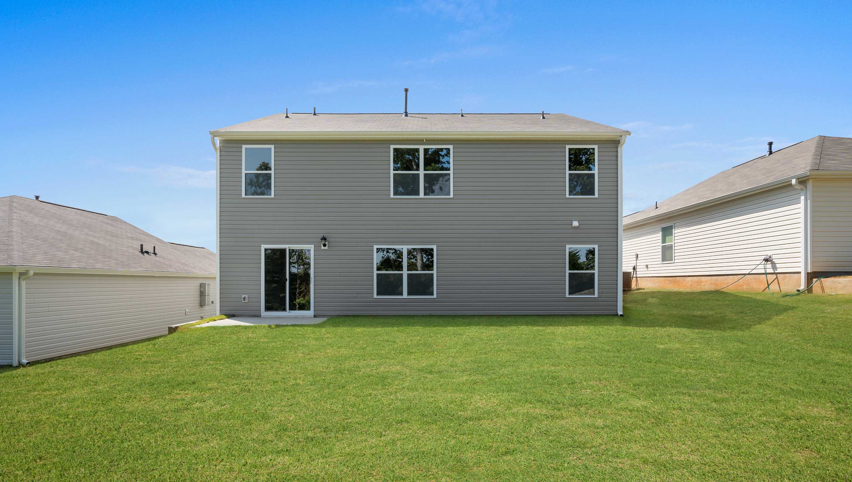 Back exterior of home with large backyard.