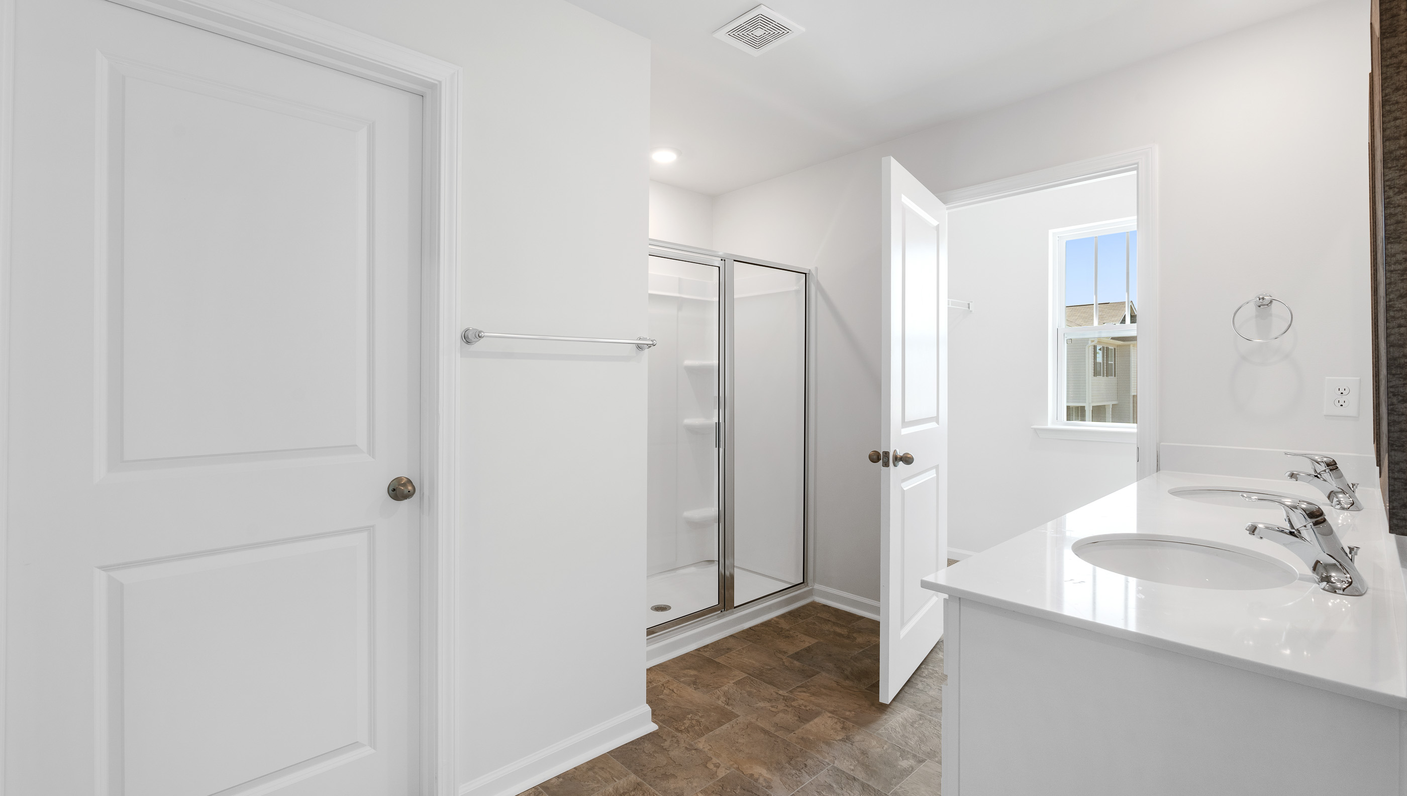 Bathroom with double vanity sink and walk in shower.