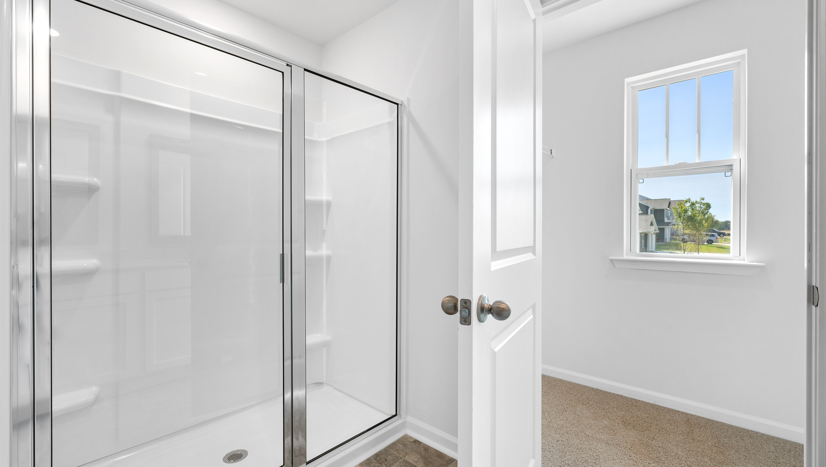 Bathroom with double vanity sink and walk in shower.