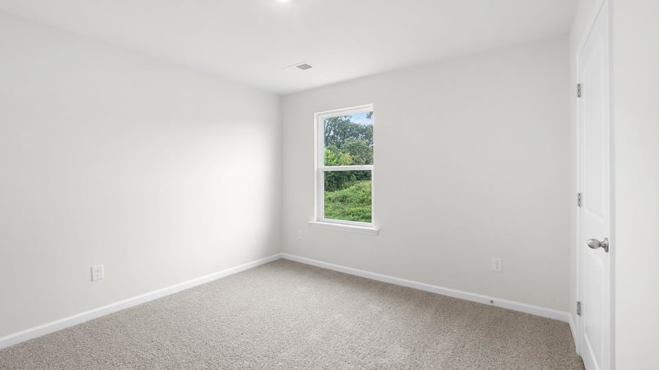 Bedroom with carpet and window.