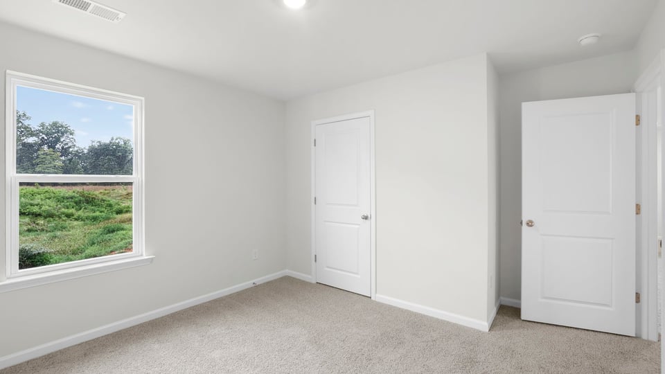 Bedroom with carpet and window.