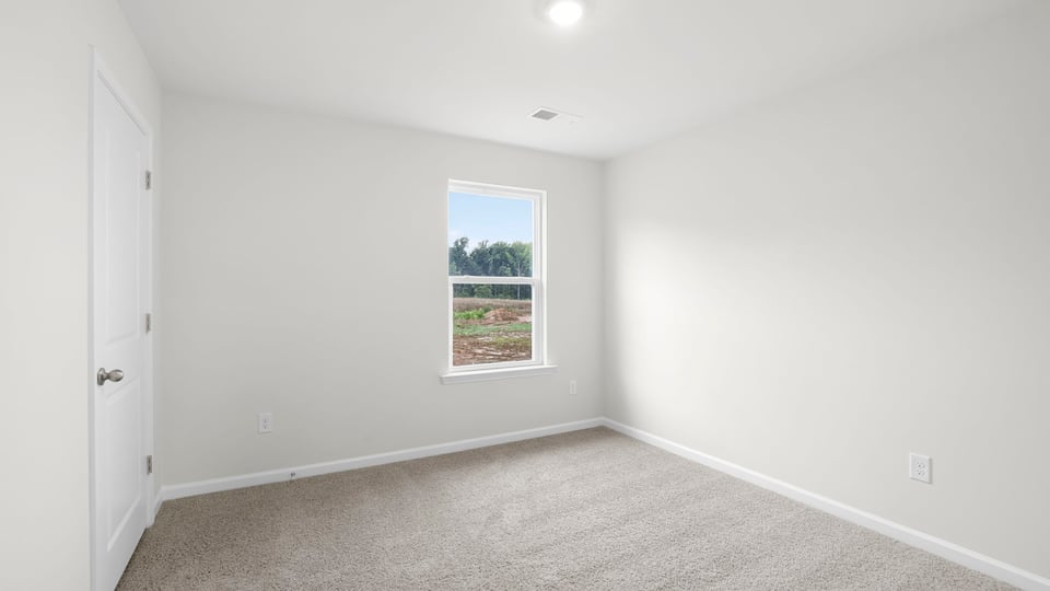 Bedroom with carpet and window.