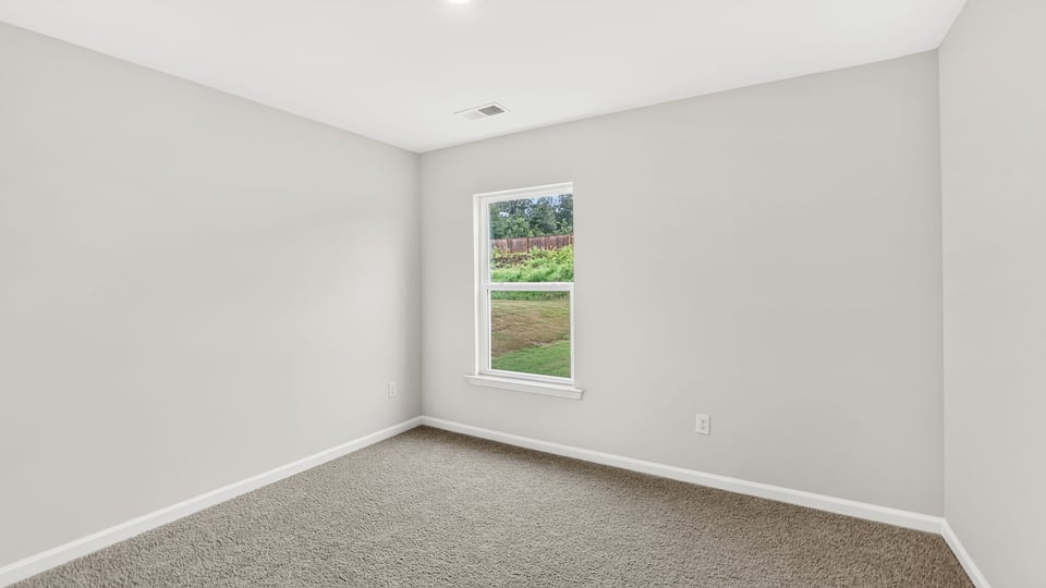 Bedroom with carpet and window.