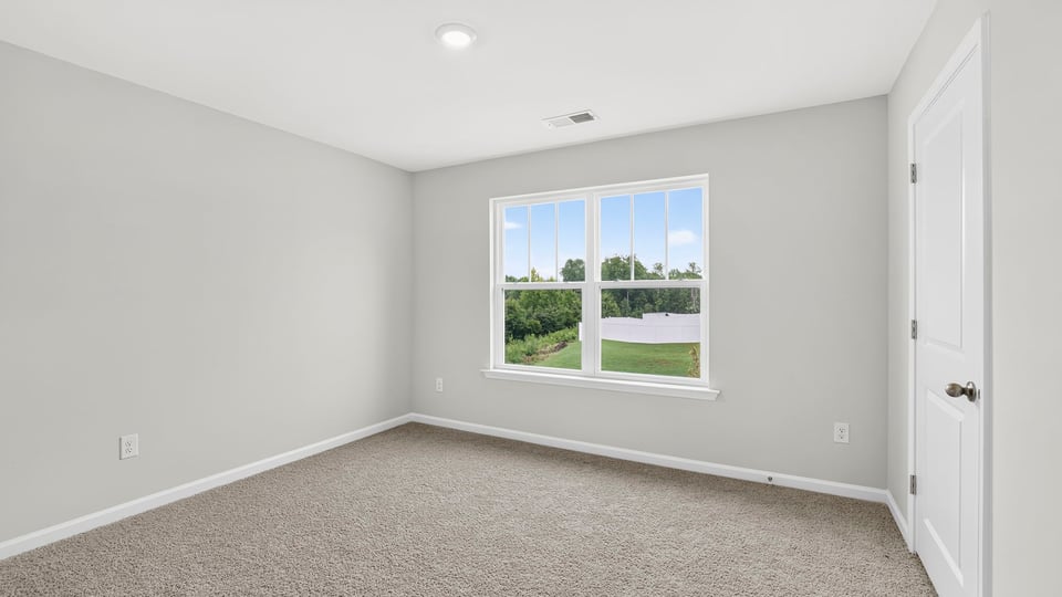 Bedroom with carpet and window.