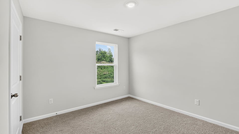 Bedroom with carpet and window.